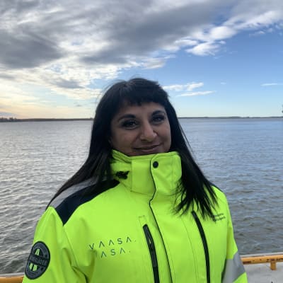 Jessica Ekström står med varseljacka vid hamnen i Vasa en höstdag. I bakgrunden ses ett lastfartyg. 