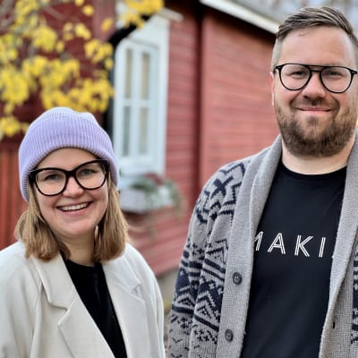 En kvinna och en man framför ett hus.