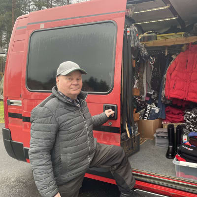 Kulkukauppias Kaarle "Kalle" Pelkonen seisoo vaatteita täynnä olevan pakettiautonsa sivustalla.