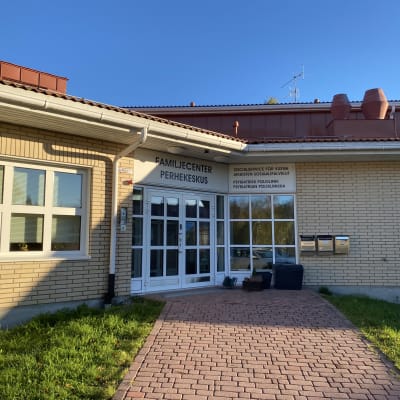 En dörr i ett tegelhus med en skylt där det står familjecenter.