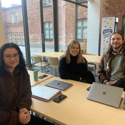 Tre stycken studerande sitter vid ett bord i Academill i Vasa. 