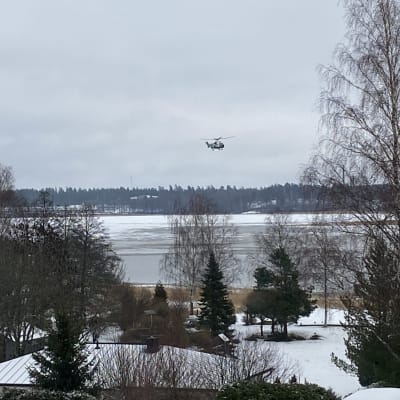 En helikopter ovanför Pojoviken i Österby en grå dag i januari.