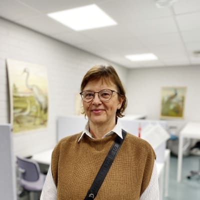 Susanne Bergström-Nyberg i ett lärarrum. Några fågelplanscher i bakgrunden.