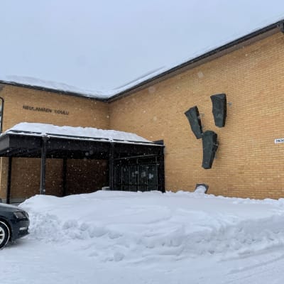 Koulurakennus lumisateessa.