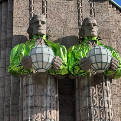 Stenmännen-statyerna iklädda klargröna boleros.