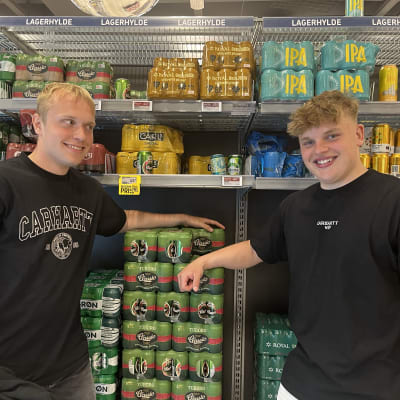 Två unga pojkar framför ölhyllan i en butik i Danmark.