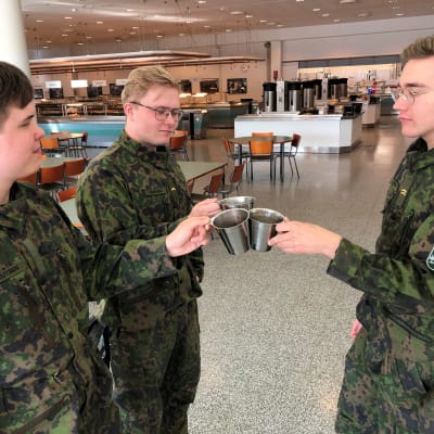 Jääkäri Santeri Knuutinen, korpraali Jaakko Hunnakko ja alikersantti Tini Kopra kilistelevät peltimukeja Niinisalon varuskunnan ravintolassa.