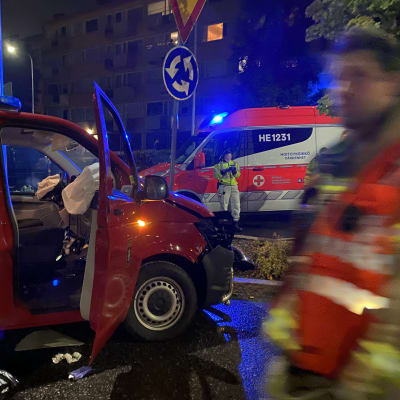 En manskapsbil som tillhör Österby FBK som stulits. Bilen har krockad och framdel är skadad. Bilens högra dörr är öppen. I bakgrunden en ambulans.