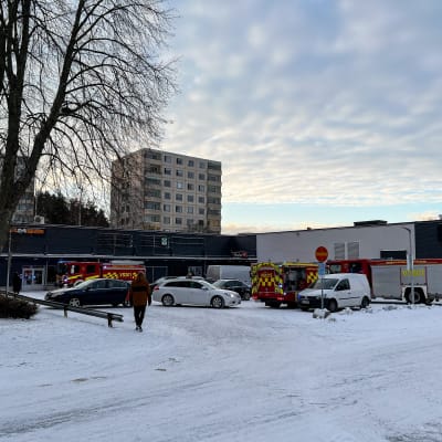 Paloautoja Turun Runosmäessä K-Market Runoksessa. Maassa on lunta. Taivas on kirkas ja vähäpilvinen.
