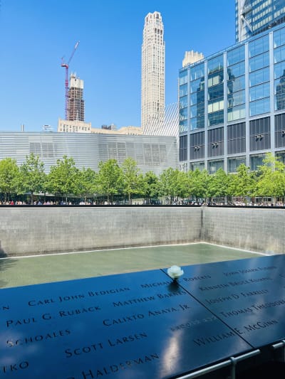 Musta kivipaasi, jossa ihmisten nimiä, päällä valkoinen ruusu, World Trade Centerin muistosuihkulähde, muistomerkki terrori-iskussa menehtyneille, New York, Yhdysvallat.