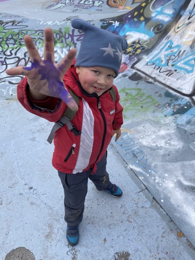 Kasper Tattari, 9 år, visar upp sin hand som har målfärg på sig.