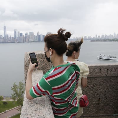 Turister tittar på Frihetsgudinnan i New York.