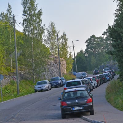 Bilar parkerade på båda sidor längs en landsväg. 