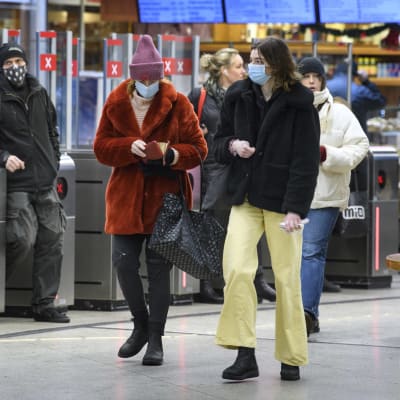 Resenärer i tunnelbana i Stockholm bär munskydd.