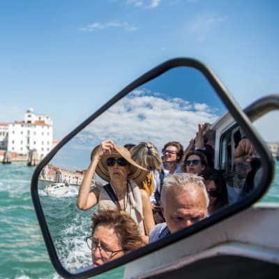 Turister på båtfärd i Venedig.