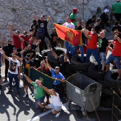 Människor demonstrerar med Monenegros flagga.