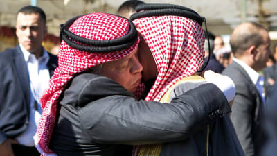 Kung Abdullah av Jordanien (t.v.) omfamnar den mördade piloten Moaz al-Kasasbehs far Safi al-Kasasbeh i dennes hemby Ayr.