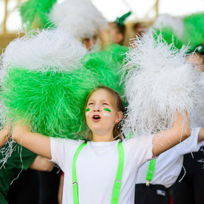 Cheerleading på stafettkarnevalen, ungdomar med vita och gröna pom-poms