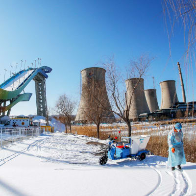 Shougang teollisuusalue lumilautailumäen taustalla Pekingissä.