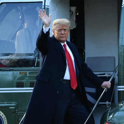 Donald Trump vinkar på väg in i en helikopter.