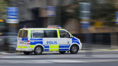 Svensk polisbil kör på gatan.