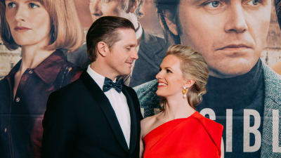 Aviopari Pelle ja Sophia Heikkilä katsovat toisiaan silmiin punaisella matolla.