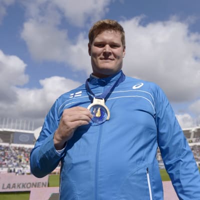 Olli-Pekka Karjalainen visar upp sitt EM-guld på Olympiastadion i Helsingfors.