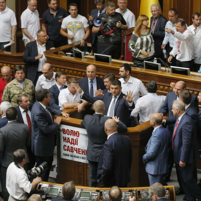 Ihmiset ympäröivät puhemies Volodymyr Hroismania Ukrainan parlamentissa.