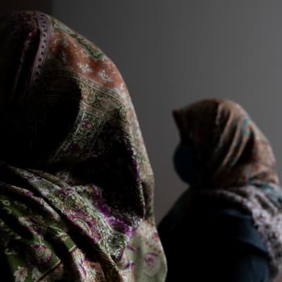 Kaksi afgaani naista huivit päässä ja kasvot varjossa.