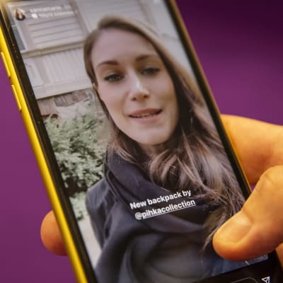Bild på en hand som håller i en telefon som visar Sanna Marin på hennes Instagramkonto.