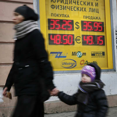 Valuutanvaihtopisteen taulu ilmoitti ruplan arvon suhteessa dollariin ja euroon Pietarissa 25. helmikuuta 2014.
