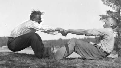 Två män leker "vetukapul", som är en slags dragkamp. Bilden är tagen 1933 i Pargas, Malm.