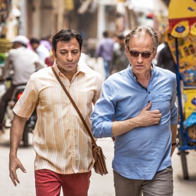 YOgi och Göran på går på en trång gata i Indien.