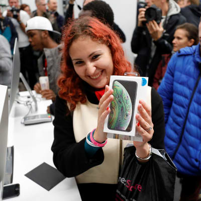 Iloinen asiakas reagoi uusien iPhone XS- ja XS Max -älypuhelinten myynnin lanseerauksen aikana Applen "re:Store" -jälleenmyyjäliikkeessä Moskovassa.