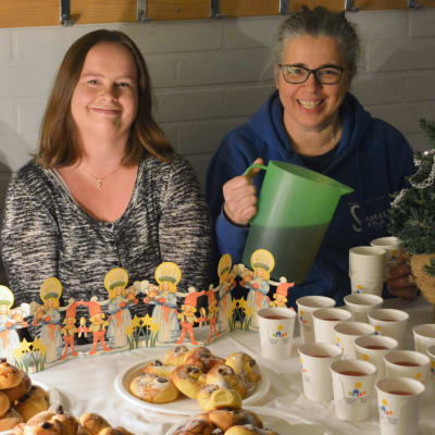 Föräldrar sitter bakom ett bord med lussekatter och saft