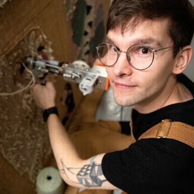 Joonas Salo katsoo kameraan tuftaustyön ääreltä.