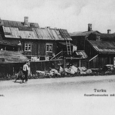 Turun Aninkaistenmäki kuvattuna vuonna 1904. Puutaloja kylki kyljessä. Ihmisiä kävelee tien viertä.