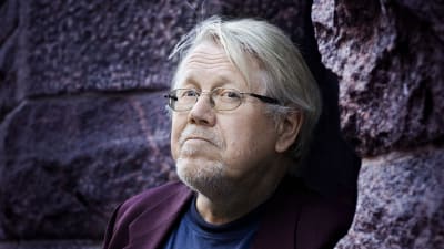 författaren Lars Sund står invid ett berg