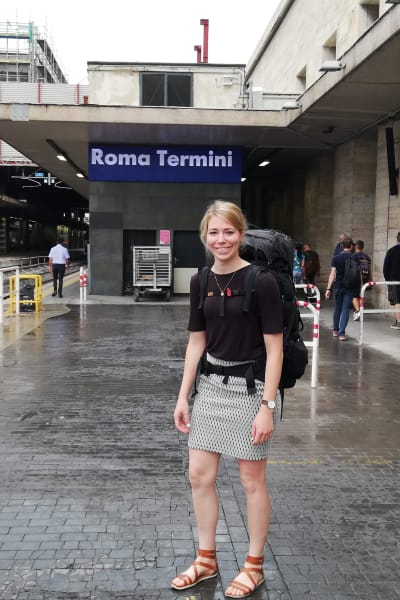 Mette Pökelmann på tågstationen i Rom med en ryggsäck på ryggen.