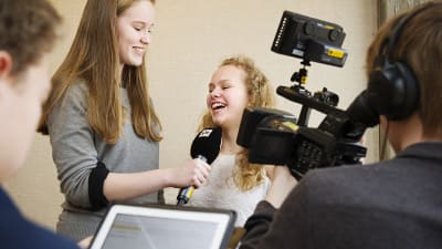 En intervjusituation med en kameraman på plats för att filma.