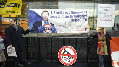 Aktivister som motsätter sig frihandelsavtalet Ceta med Kanada, visar upp en banderoll med en bild av premiärminister Paul Magnette och texten "3,4 miljoner europeer litar på Vallonien."