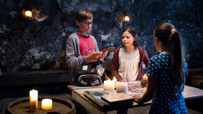 Barnen i serien Piratskattens hemlighet har samlats kring ett bord och diskuterar.
