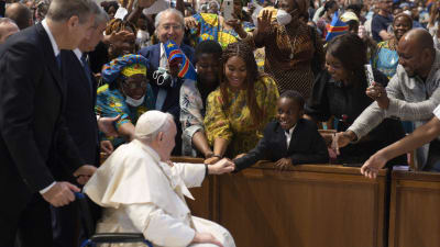 Påven i rullstol hälsar glatt på kongolesiska katoliker i Peterskyrkan.