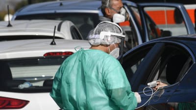 Person med covid-19-symptom får behandling inne i en bil i Neapel, Italien 9.11.2020