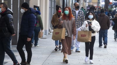 Personer går på en shoppinggata i Italien, iklädda munskydd.