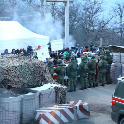 Azerbajdzjanska aktivister blockerar vägen till Latjinkorridorden medan ryska fredsbevarare tittar på.