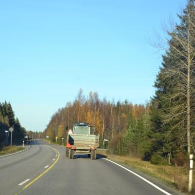 Traktor kör på väg.