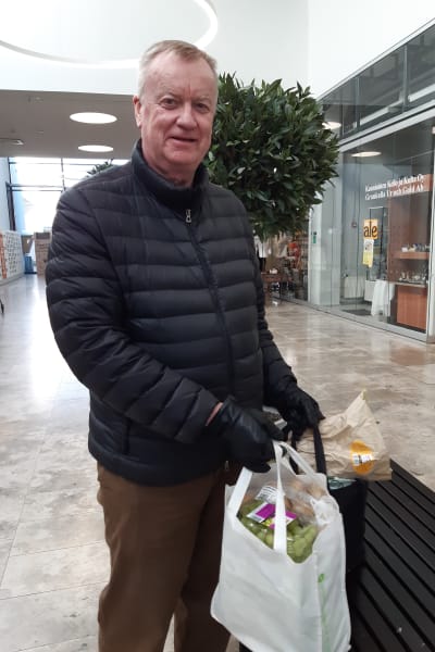 Foto på Raul Henriksson som står med två välfyllda matkassar.