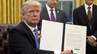 Donald Trump visar ett dekret han undertecknat om att USA drar sig ur TPP.