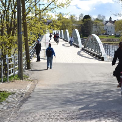 Cyklister och fotgängare påväg över en bro över älven i Umeå